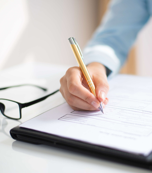 A handwriting on paper with a pen, symbolizes the precision of work and commitment to detail in the services provided by Saudi RNA.